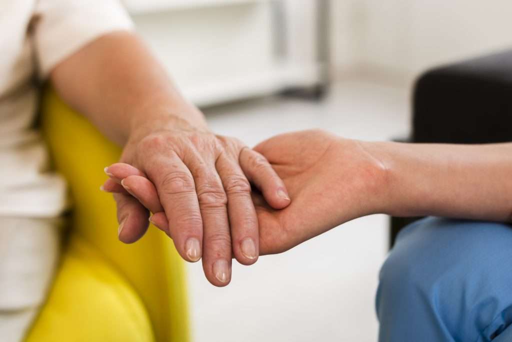 someone holding the hand of a patient